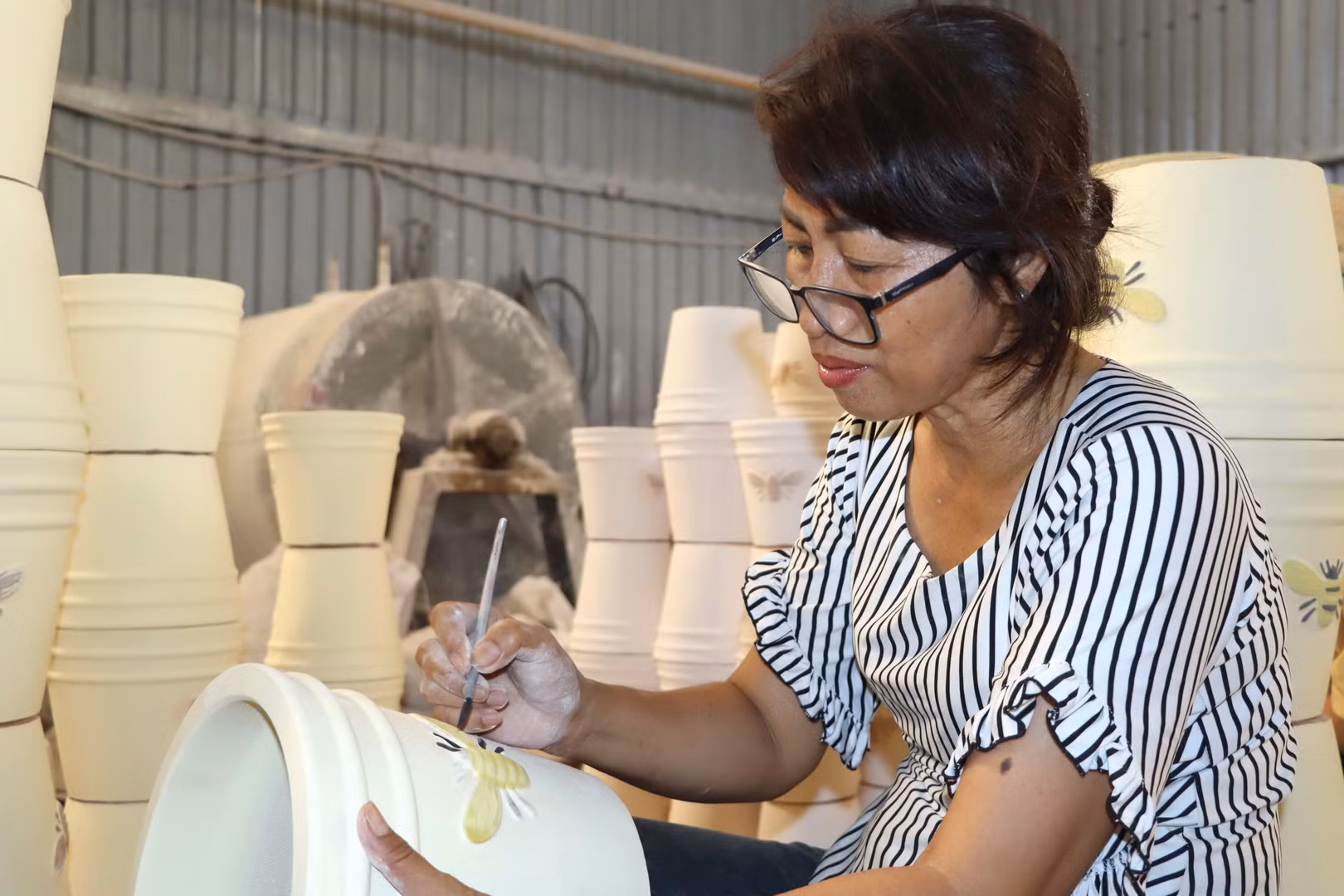 Thợ gốm có nhiều năm kinh nghiệm đang chạm khắc hoa văn lên sản phẩm. Thợ gốm có nhiều năm kinh nghiệm đang chạm khắc hoa văn lên sản phẩm.