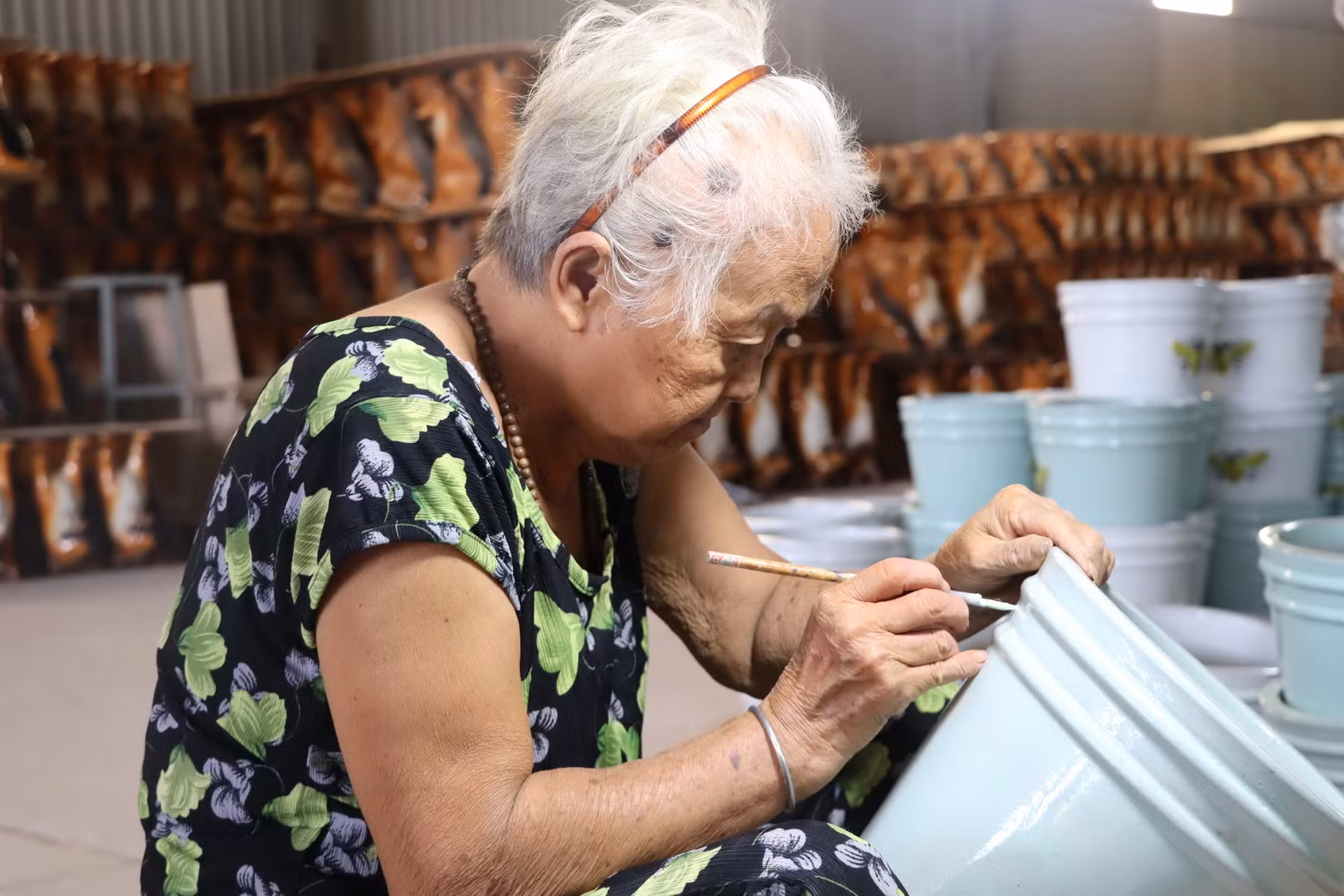 Một người thợ cao tuổi khắc hoa văn lên sản phẩm gốm Biên Hòa.