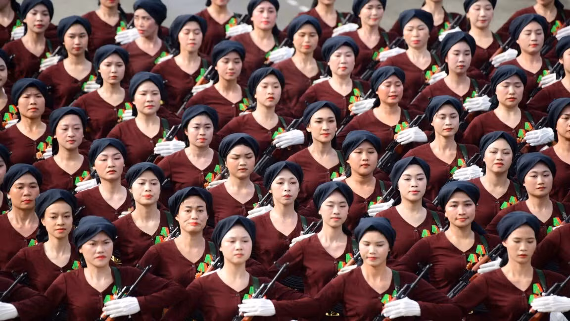 Khối nữ dân quân miền bắc, với màu áo nâu đội khăn mỏ quạ. Khối nữ dân quân miền bắc, với màu áo nâu đội khăn mỏ quạ.