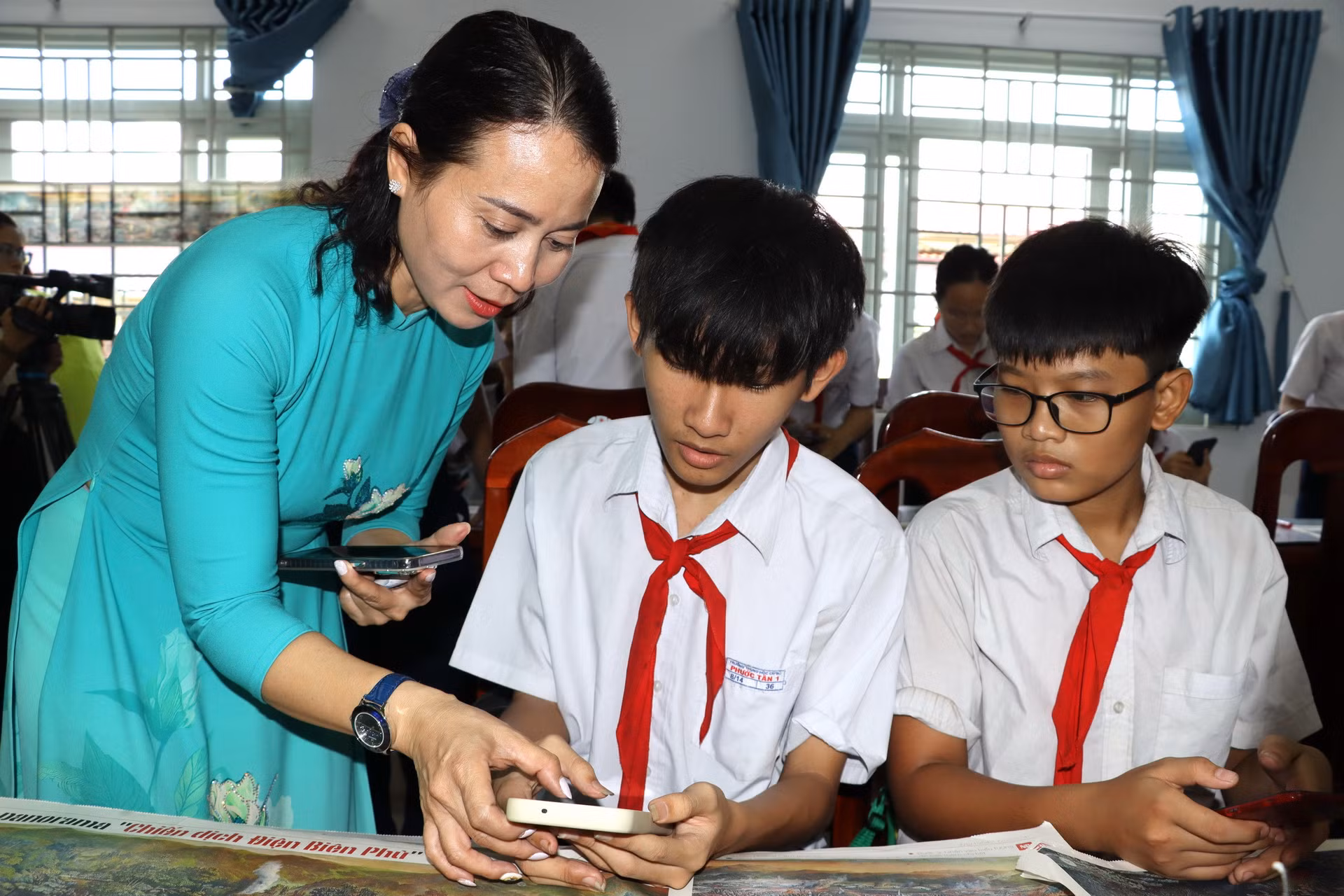 Cô giáo Phạm Thị Nam, Hiệu trưởng Trường trung học cơ sở Phước Tân 3 hướng dẫn học sinh quét mã QR trên tranh panorama Chiến dịch Điện Biên Phủ.