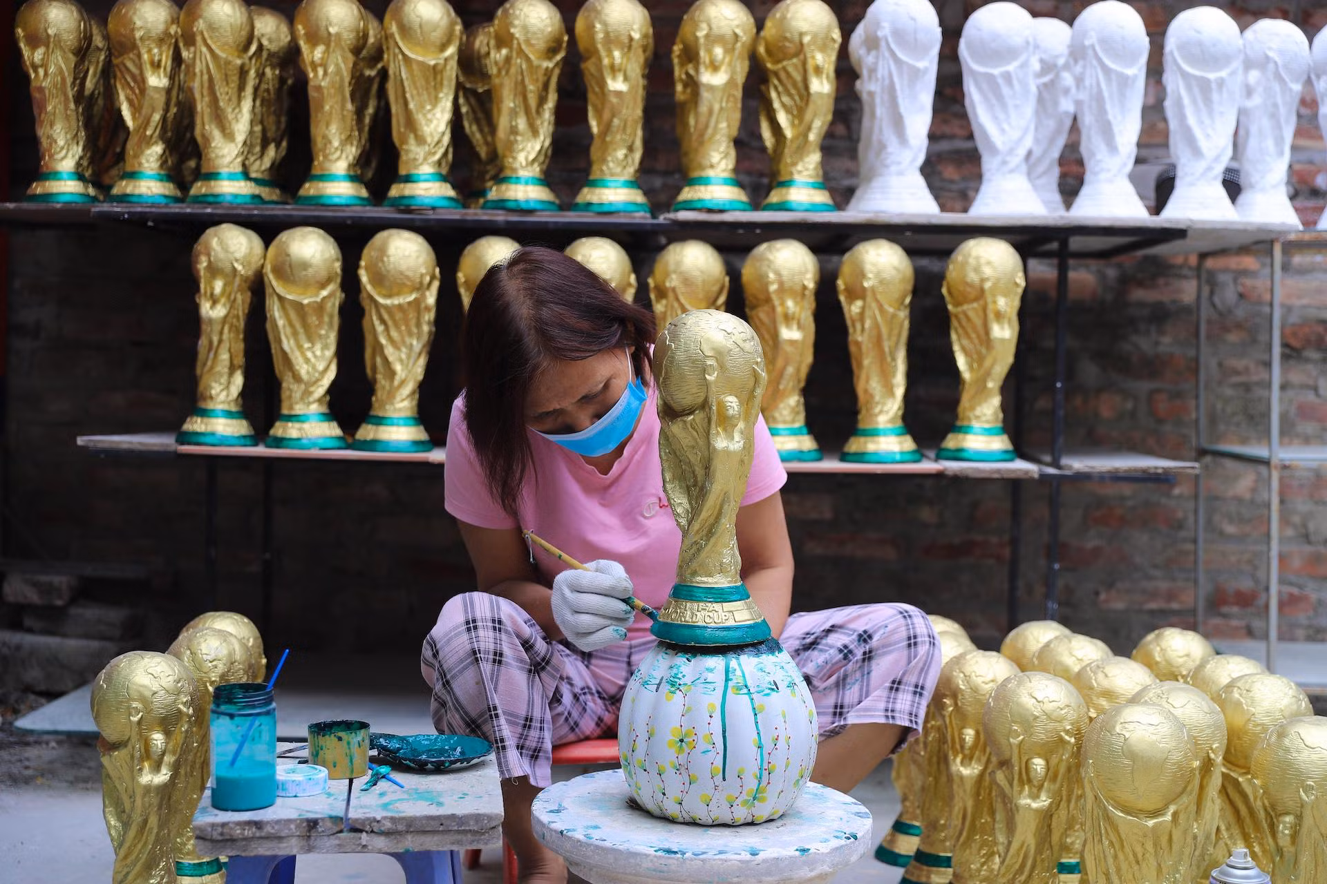 Người thợ đang hoàn thiện phần đế của chiếc cúp vàng World Cup 2022 với một lớp sơn màu xanh lá cây. Với bàn tay khéo léo của người Bát Tràng, những chiếc cúp vàng World Cup phiên bản Việt Nam được ra đời. Người thợ đang hoàn thiện phần đế của chiếc cúp vàng World Cup 2022 với một lớp sơn màu xanh lá cây. Với bàn tay khéo léo của người Bát Tràng, những chiếc cúp vàng World Cup phiên bản Việt Nam được ra đời.