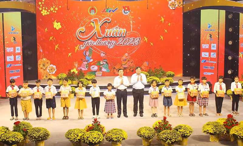 Phó Bí thư Thường trực Tỉnh ủy, Chủ tịch Hội đồng nhân dân tỉnh Hậu Giang Trần Văn Huyến (bên trái) và Phó Giáo sư, tiến sĩ Nguyễn Quốc Dũng, Giám đốc Học viện Chính trị khu vực II, trao quà cho các cháu.