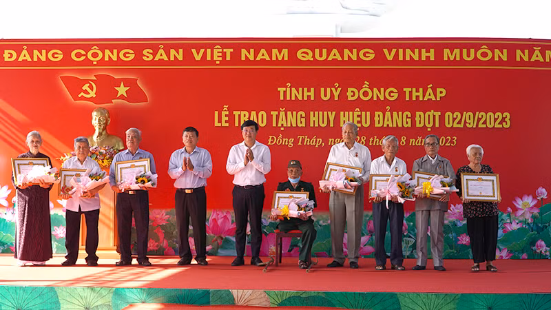 Bí thư Tỉnh ủy Đồng Tháp Lê Quốc Phong trao Huy hiệu Đảng cho các đảng viên. (Ảnh: HỮU NGHĨA)