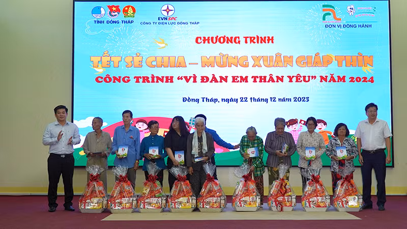 Chủ tịch Ủy ban nhân dân huyện Tháp Mười Đoàn Thanh Bình và Phó Giám đốc Công ty Điện lực Đồng Tháp Nguyễn Chí Thanh trao tặng quà. (Ảnh: HỮU NGHĨA)