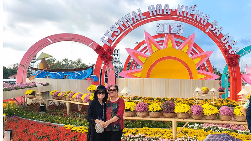 Du khách chụp ảnh lưu niệm tại một cụm tiểu cảnh tại Festival Hoa-kiểng Sa Đéc. (Ảnh: HỮU NGHĨA)