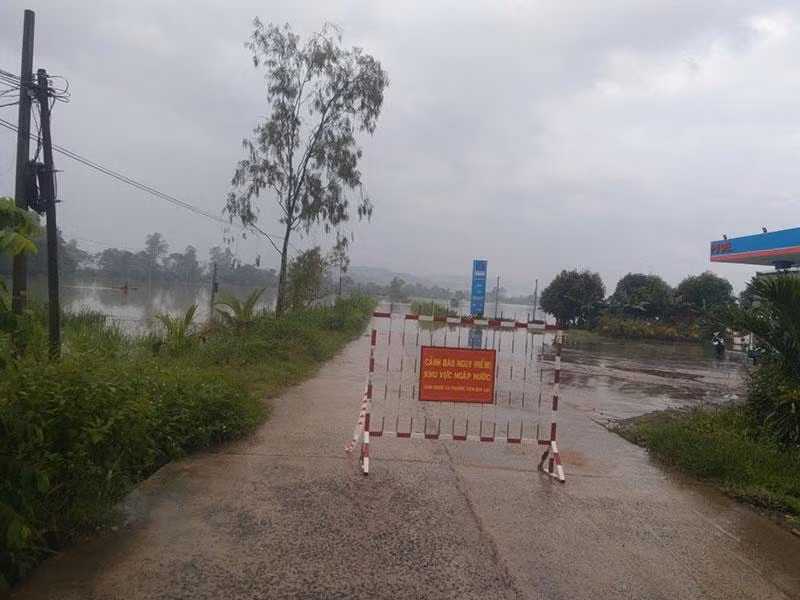 Lực lượng chức năng cắm biển báo không cho người và phương tiện qua lại trên các tuyến giao thông bị ngập ở huyện Đồng Xuân.