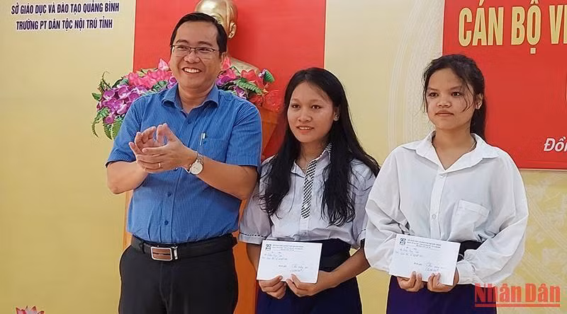 Đại diện Sở Giáo dục và Đào tạo Quảng Bình tặng quà cho 2 nữ sinh dân tộc thiểu số trúng tuyển đại học.
