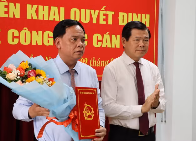 Bí thư Tỉnh ủy Đồng Nai Nguyễn Hồng Lĩnh trao quyết định và tặng hoa chúc mừng đồng chí Võ Tấn Đức.