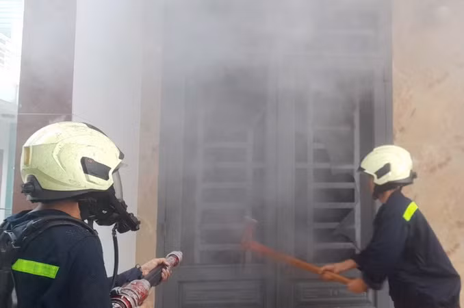 Lực lượng Cảnh sát phá cửa căn nhà để tiếp cận hiện trường bên trong.