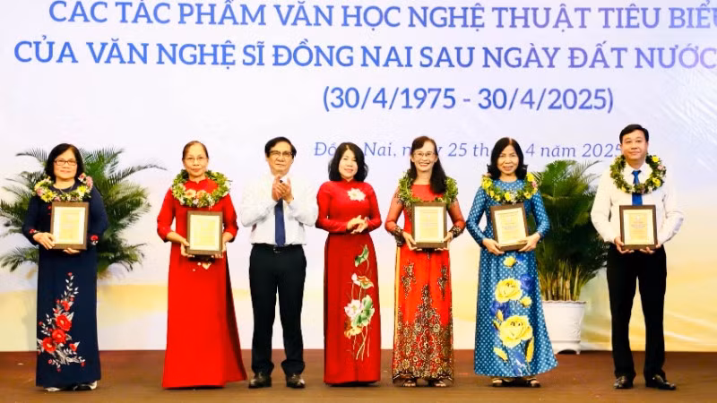 Phó Chủ tịch HĐND tỉnh Đồng Nai Hoàng Thị Bích Hằng và Phó Chủ tịch UBND tỉnh Nguyễn Sơn Hùng trao biểu trưng tôn vinh cho đại diện gia đình các văn nghệ sĩ.