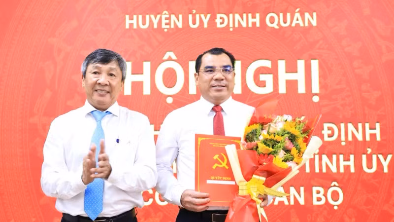 Phó Bí thư Thường trực Tỉnh ủy Hồ Thanh Sơn trao quyết định và tặng hoa chúc mừng tân Bí thư Huyện ủy Định Quán.