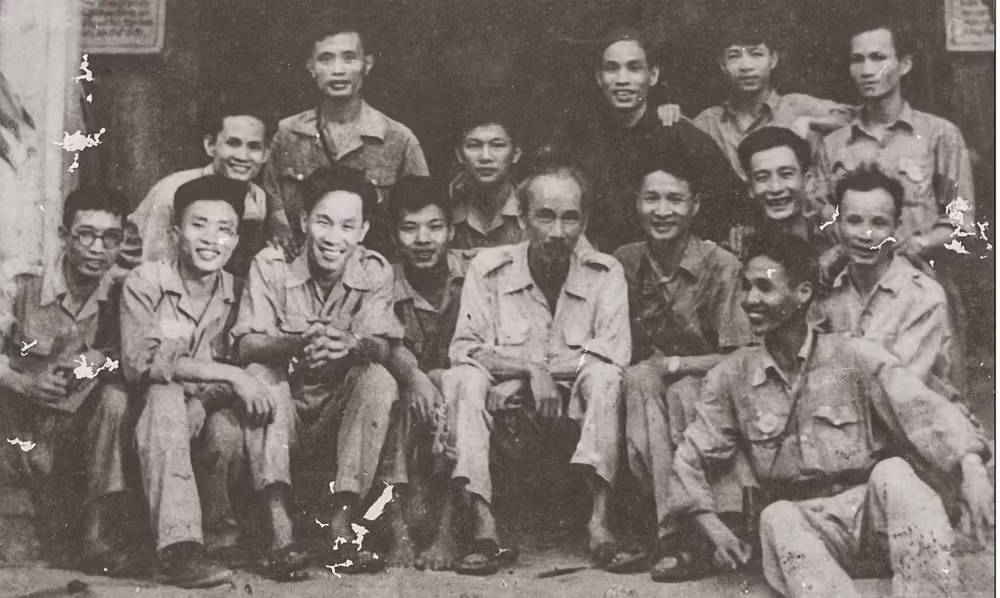 Chủ tịch Hồ Chí Minh cùng các cán bộ phòng Điện ảnh - Nhiếp ảnh phục vụ Đại hội Đại biểu toàn quốc lần thứ II của Đảng tại Chiến khu Việt Bắc - 1951. (Nguồn: Cục Điện ảnh) Từ trái sang Hàng đầu: 1: chưa xác định; 2: Quay phim Phan Nghiêm; 3: Quay phim Nguyễn Tiến Lợi, 4: Quay phim Hoàng Thái; 5: Chủ tịch Hồ Chí Minh; 6: Nhiếp ảnh Đinh Đăng Định; 7: Quay phim Nguyễn Đăng Bảy. Hàng thứ hai: 1: Đạo diễn Lê Minh Hiền; 2: chưa xác định; 3: Quay phim Nguyễn Thụ; 4: chưa xác định; 5: Nhiếp ảnh Tô Na.