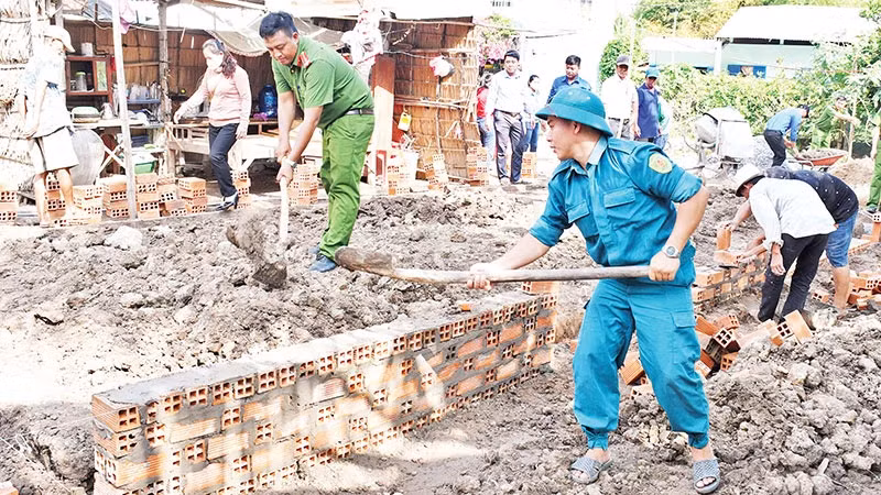 Lực lượng vũ trang cùng các đoàn thể chính trị xã Huyền Hội, huyện Càng Long, tỉnh Trà Vinh, hỗ trợ người dân xây nhà. (Ảnh: KHỞI - GIANG)