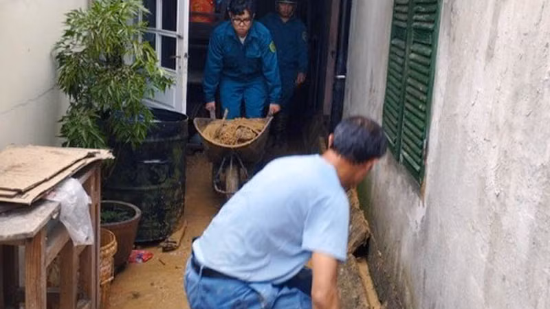 Lực lượng chức năng hỗ trợ người dân khắc phục hậu quả do mưa lớn.