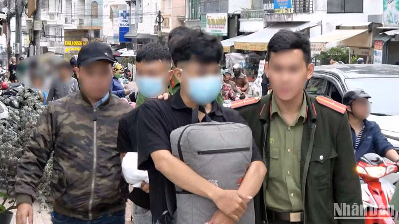 Hai đối tượng phát "danh thiếp lạ" nhằm chiếm đoạt tài sản trên không gian mạng bị lực lượng chức năng bắt quả tang. (Ảnh: Công an cung cấp)