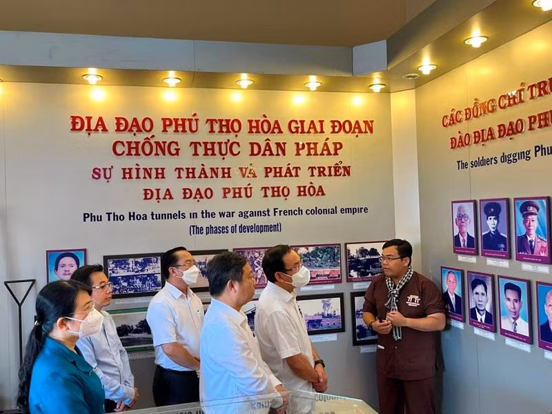 Đồng chí Nguyễn Văn Nên và đoàn công tác nghe thuyết minh về quá trình hình thành và phát triển của địa đạo Phú Thọ Hòa.