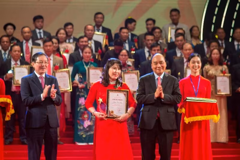 Đồng chí Nguyễn Xuân Phúc, Ủy viên Bộ Chính trị, Chủ tịch nước Cộng hòa xã hội chủ nghĩa Việt Nam; và đồng chí Lương Quốc Đoàn, Ủy viên Trung ương Đảng, Chủ tịch Ban Chấp hành Trung ương Hội Nông dân Việt Nam, trao danh hiệu và kỷ niệm chương cho các nông dân xuất sắc thuộc lĩnh vực Khởi nghiệp, sáng chế, chuyển đổi số. (Ảnh: TRUNG HƯNG)
