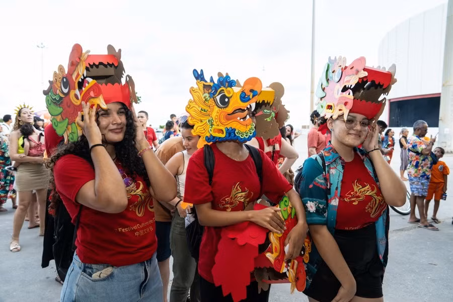 Người dân thích thú với những chiếc mũ hình rồng đón Tết Nguyên đán của người châu Á tại công viên ở Recife, Brazil. (Ảnh: THX/TTXVN)