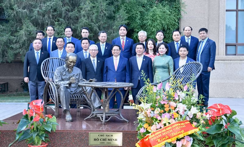 Thủ tướng Phạm Minh Chính và các đồng chí lãnh đạo chụp ảnh lưu niệm bên Tượng đài Chủ tịch Hồ Chí Minh trong khuôn viên Đại sứ quán Việt Nam tại Trung Quốc.