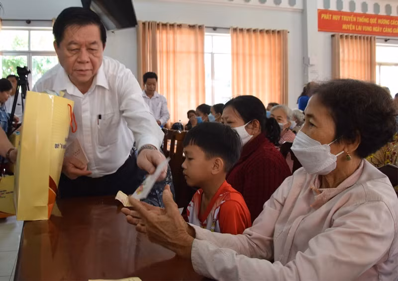 Đồng chí Nguyễn Trọng Nghĩa tặng quà cho các gia đình có hoàn cảnh khó khăn.