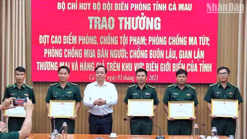 Chủ tịch Ủy ban nhân dân tỉnh Cà Mau Huỳnh Quốc Việt (áo trắng) tặng Bằng khen cho tập thể, cá nhân Biên phòng Cà Mau có thành tích tốt trong phá án về buôn lậu, ma túy.