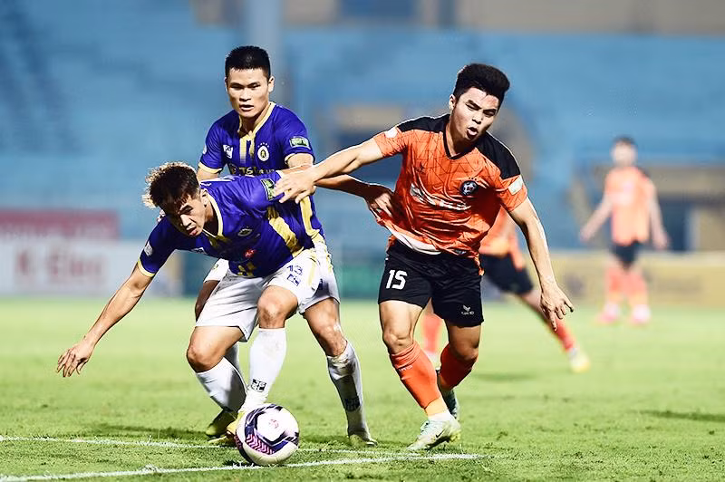 Pha tranh bóng giữa cầu thủ đội Hà Nội FC (áo tím) và cầu thủ đội SHB Đà Nẵng. (Ảnh: TRẦN HẢI)