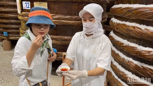 Du khách nếm vị thành phẩm rút trực tiếp từ thùng ủ. Du khách nếm vị thành phẩm rút trực tiếp từ thùng ủ.