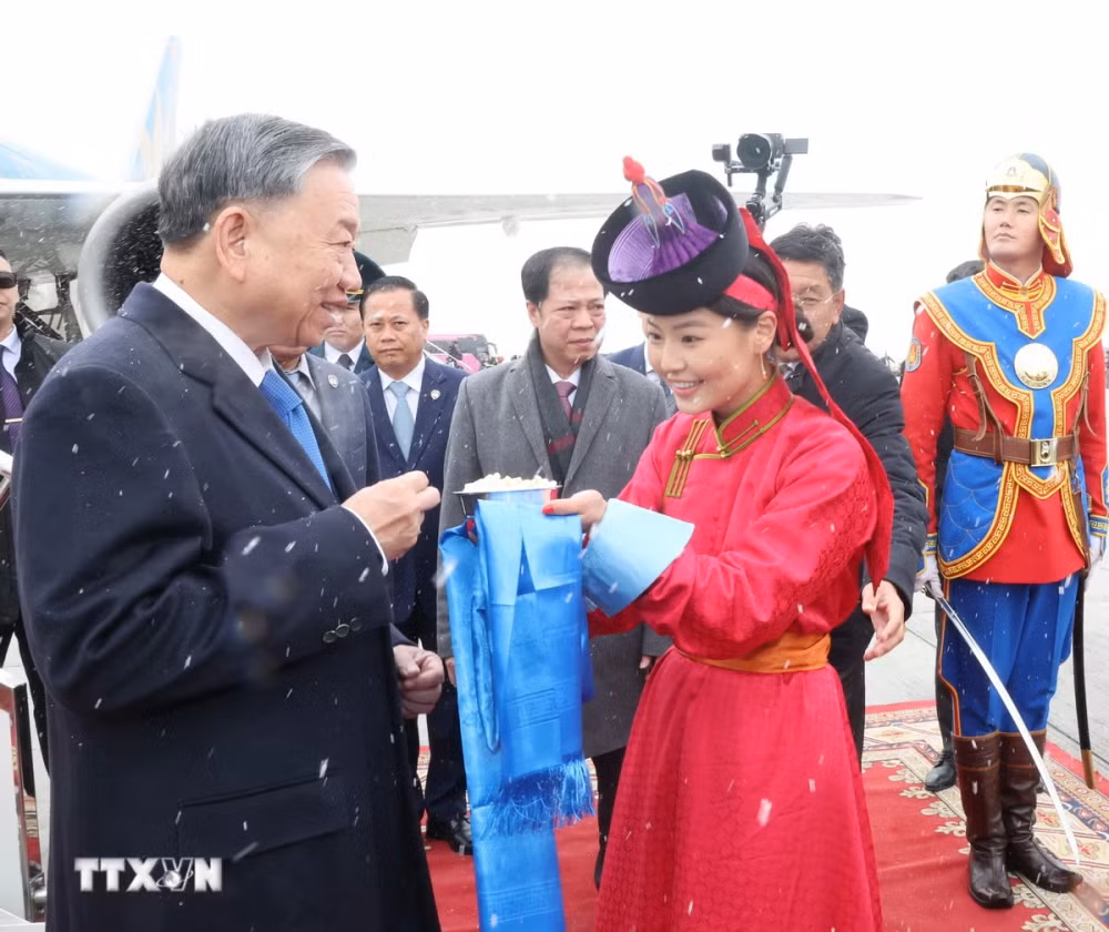 Thiếu nữ Mông Cổ dâng bánh sữa theo phong tục truyền thống và tặng hoa đón Tổng Bí thư, Chủ tịch nước Tô Lâm tại sân bay Thành Cát Tư Hãn (Chinggis Khaan International Airport) ở Thủ đô Ulan Bator. Ảnh: Trí Dũng/TTXVN