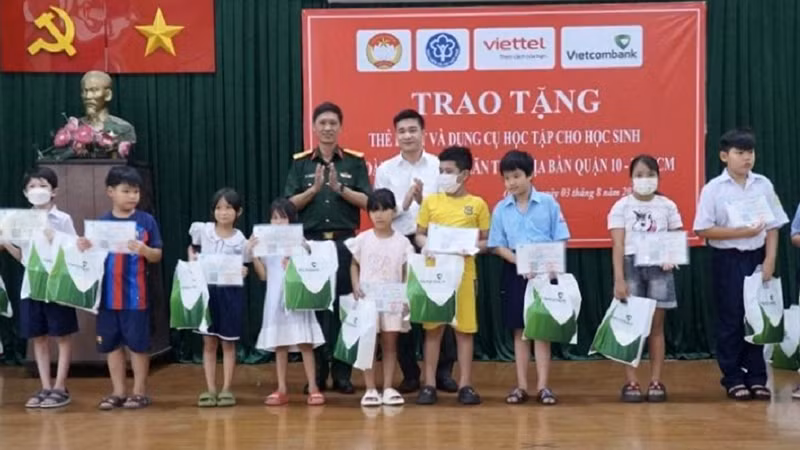 Lãnh đạo Bảo hiểm xã hội Thành phố Hồ Chí Minh và nhà tài trợ tặng thẻ bảo hiểm y tế cho học sinh khó khăn ở địa bàn, tháng 8/2023 (Ảnh: HSS)