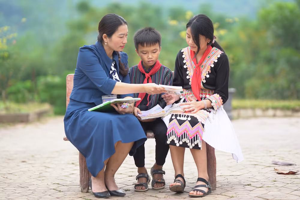 Cô giáo Lê Na hướng dẫn bài tập Ngữ văn cho học sinh là con em đồng bào dân tộc thiểu số tại sân Trường Phổ thông dân tộc nội trú trung học cơ sở Kỳ Sơn (huyện Kỳ Sơn, tỉnh Nghệ An).