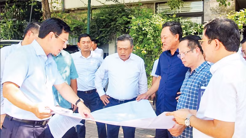 Chủ tịch UBND thành phố Hà Nội Trần Sỹ Thanh (đứng giữa) kiểm tra thực tế tại ô đất xây dựng trường học thuộc khu chức năng đô thị Ao Sào, Thịnh Liệt, quận Hoàng Mai. (Ảnh THỦY TIÊN)