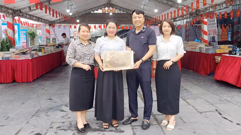 Đại diện Văn phòng Báo Nhân Dân tại Quảng Ninh tặng phụ san đặc biệt "Chiến dịch Hồ Chí Minh" cho bạn đọc.