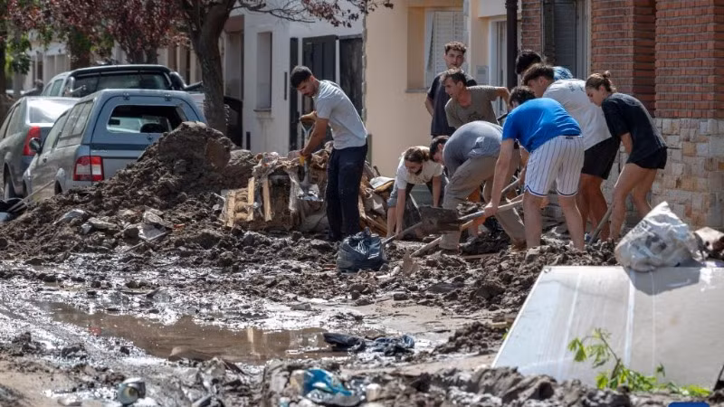 Người dân dọn bùn trên đường phố ở Bahia Blanca, Argentina, ngày 10/3/2025. (Ảnh: XINHUA)