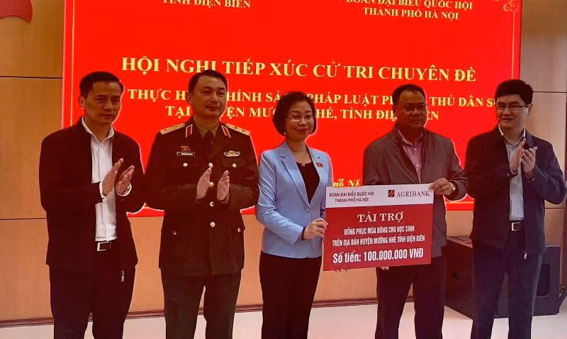 Bà Phạm Thị Thanh Mai, Phó trưởng đoàn chuyên trách Đoàn Đại biểu Quốc hội thành phố Hà Nội, trao kinh phí mua áo ấm tặng học sinh nghèo huyện Mường Nhé.