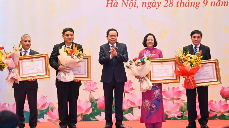Phó Chủ tịch Thường trực Quốc hội Trần Thanh Mẫn trao Huân chương Lao động và tặng hoa chúc mừng các cá nhân. (Ảnh: Duy Linh)