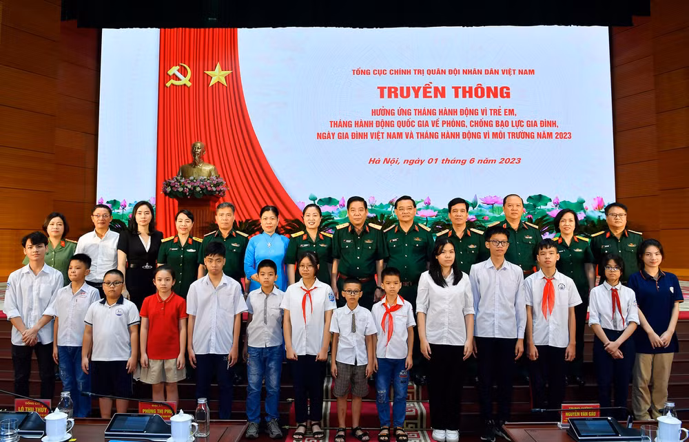 Các đại biểu chụp ảnh lưu niệm với trẻ em được nhận đỡ đầu. 