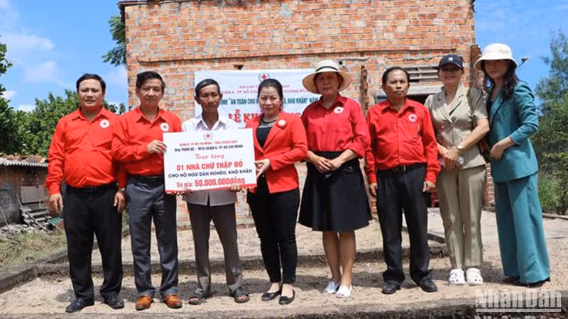 Trao biểu trưng hỗ trợ xây nhà Chữ thập đỏ cho ngư dân nghèo ở xã Đức Minh, huyện Mộ Đức. 
