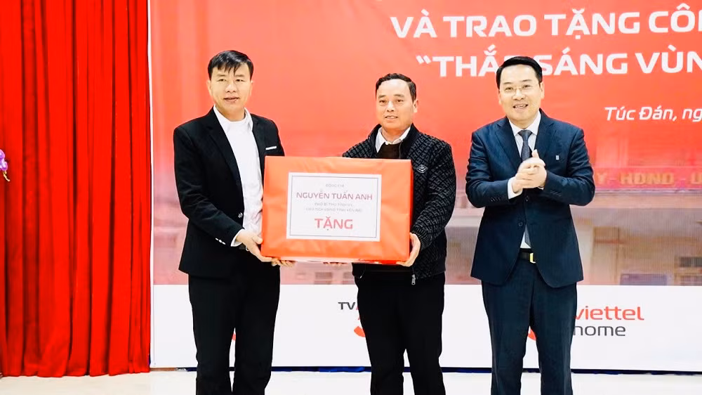 Chủ tịch Ủy ban nhân dân tỉnh Nguyễn Tuấn Anh tặng quà nhân dân xã Túc Đán. (Ảnh: THANH SƠN)