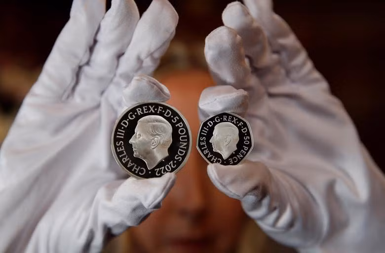 Chân dung Vua Charles III được in trên đồng 50 xu (bên phải) và 5 bảng Anh. (Ảnh: REUTERS) Chân dung Vua Charles III được in trên đồng 50 xu (bên phải) và 5 bảng Anh. (Ảnh: REUTERS)