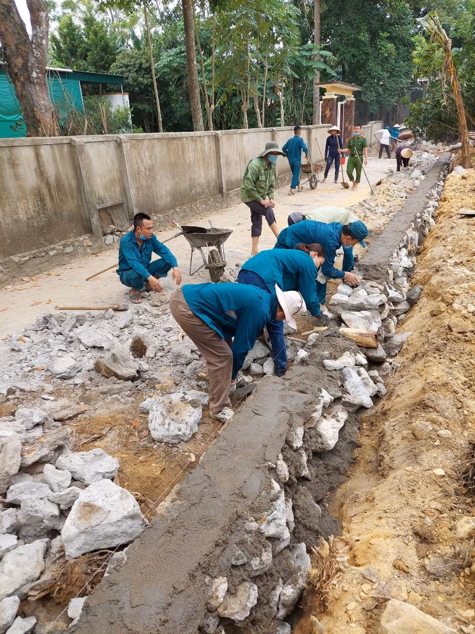Cán bộ, đảng viên xã Sơn Châu giúp các hộ dân xây dựng lại tường rào sau khi hiến đất mở rộng giao thông thôn, xóm.