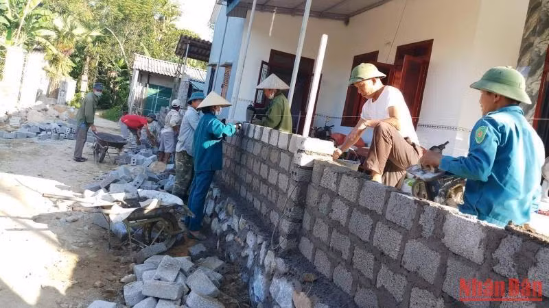 Cán bộ, đảng viên xã Sơn Châu giúp các hộ dân xây dựng lại tường rào sau khi hiến đất mở rộng đường.