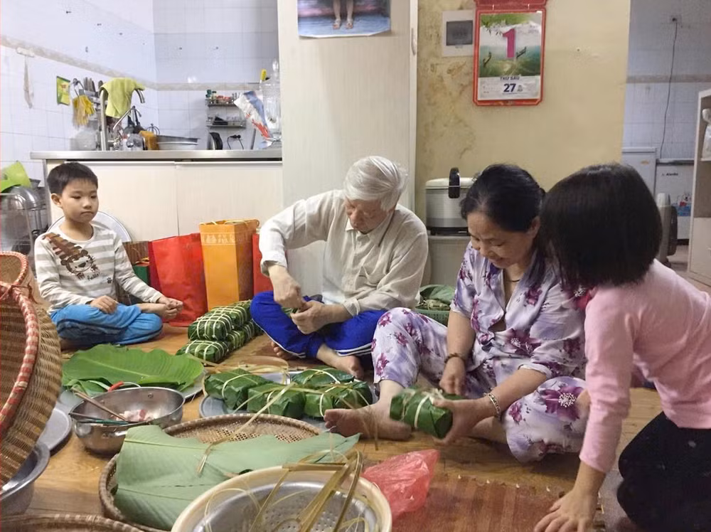 Ảnh tại triển lãm: Tổng Bí thư, Chủ tịch nước Nguyễn Phú Trọng cùng gia đình gói bánh chưng nhân dịp Tết cổ truyền của dân tộc, Xuân Kỷ Hợi - 2019. Ảnh: Văn phòng Tổng Bí thư