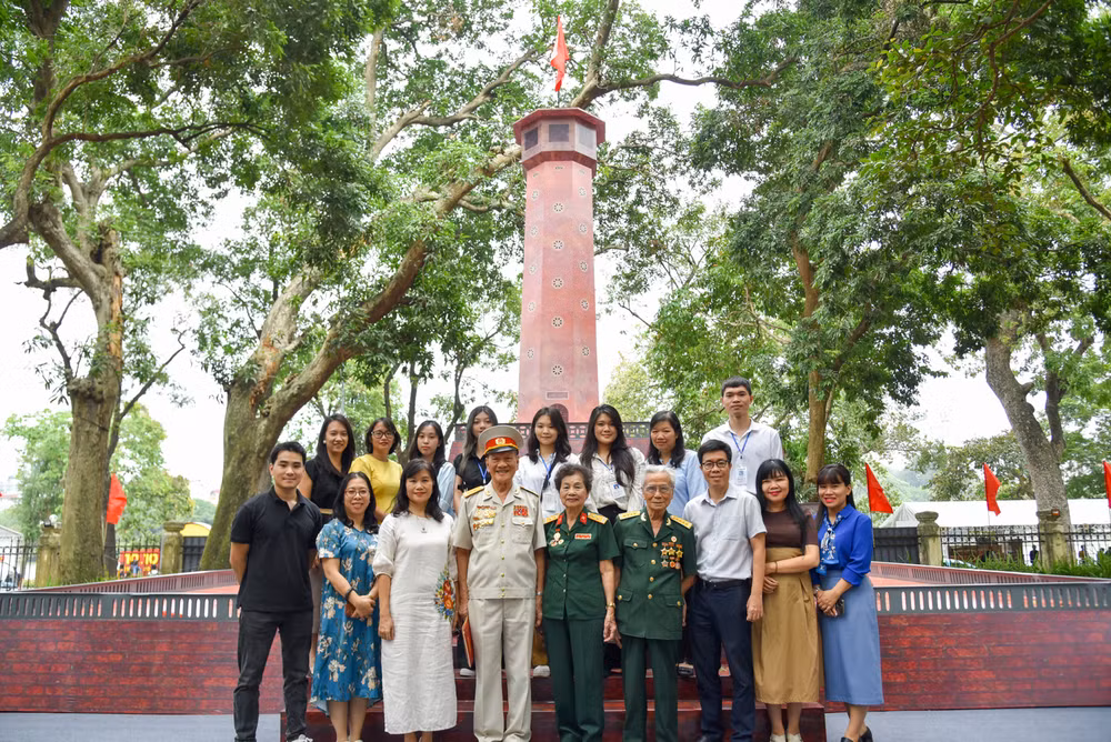 Các nhân chứng lịch sử dự giao lưu trực tuyến chụp ảnh lưu niệm cùng phóng viên Báo Nhân Dân tại Triển lãm tương tác Cột cờ Hà Nội.