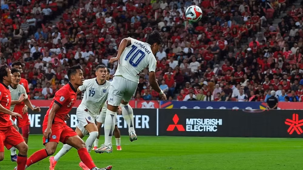 Đội tuyển Thái Lan (áo trắng) thắng Singapore 4-2 nhờ hai bàn trong phút bù giờ, tại ASEAN Cup 2024. (Ảnh FAT) 