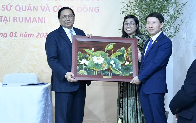 Thủ tướng Phạm Minh Chính tặng quà lưu niệm cho bà con cộng đồng người Việt Nam tại Romania. (Ảnh: THANH GIANG)