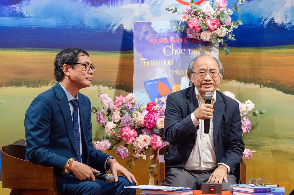 Nhà văn Phan Đức Nhạn (bên phải) chia sẻ về tập bút ký và mảnh đất quê hương anh hùng.