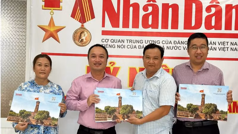 Văn phòng đại diện Báo nhân Dân tại tỉnh Bến Tre bàn giao tờ phụ san về Cột cờ Hà Nội cho Thư viện Nguyễn Đình Chiểu. (Ảnh: HOÀNG TRUNG)