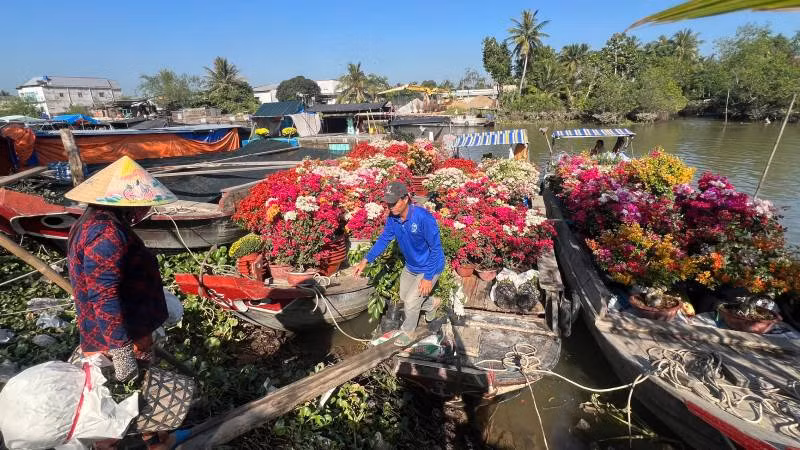 Người dân mang hoa lên ghe để vận chuyển bằng đường thủy đến chợ Tết.