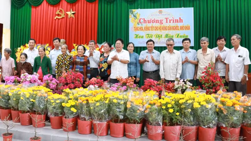 Lãnh đạo Hội Nông dân tỉnh Bến Tre cùng chính quyền địa phương trao hoa, cây kiểng cho hội viên, nông dân có hoàn cảnh khó khăn tại huyện Ba Tri. (Ảnh: HOÀNG TRUNG)
