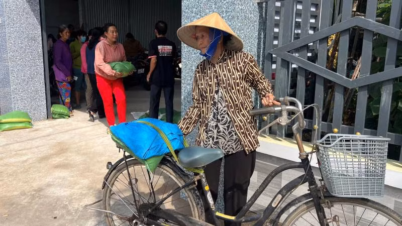 Hộ gia đình chính sách, gia đình có hoàn cảnh khó khăn đến nhận quà. (Ảnh: HOÀNG TRUNG)